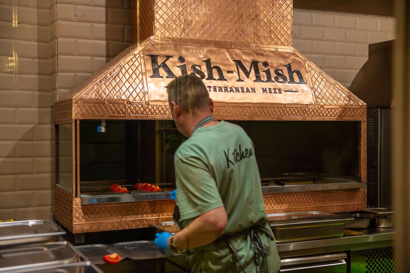 The chef at work over the copper-hooded charcoal grill