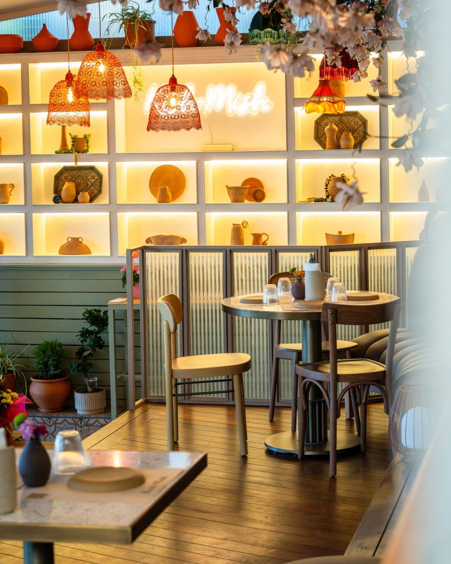Glowing shelves of pottery and a table by the neon sign