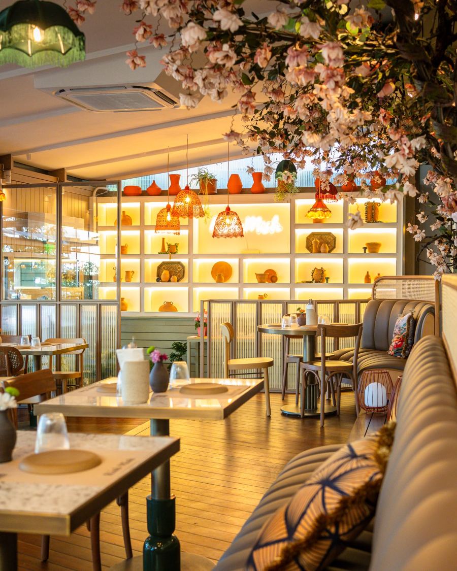 Blossom branches over cosy booths and warmly lit shelves