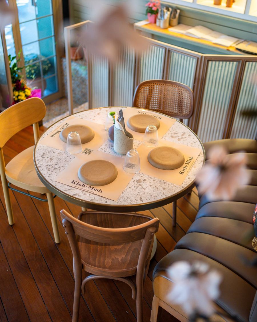 A round terrazzo table set with ceramic plates
