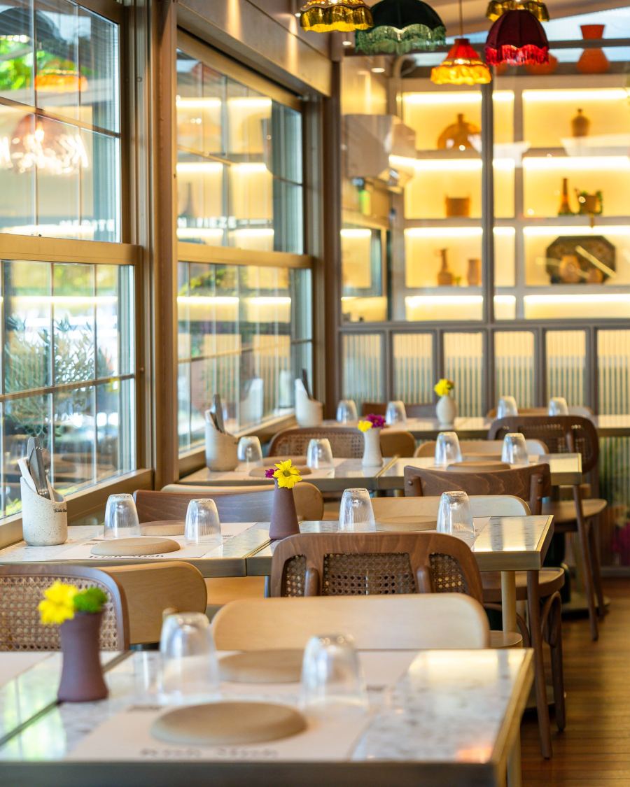 The dining room filled with evening light and coloured lamps