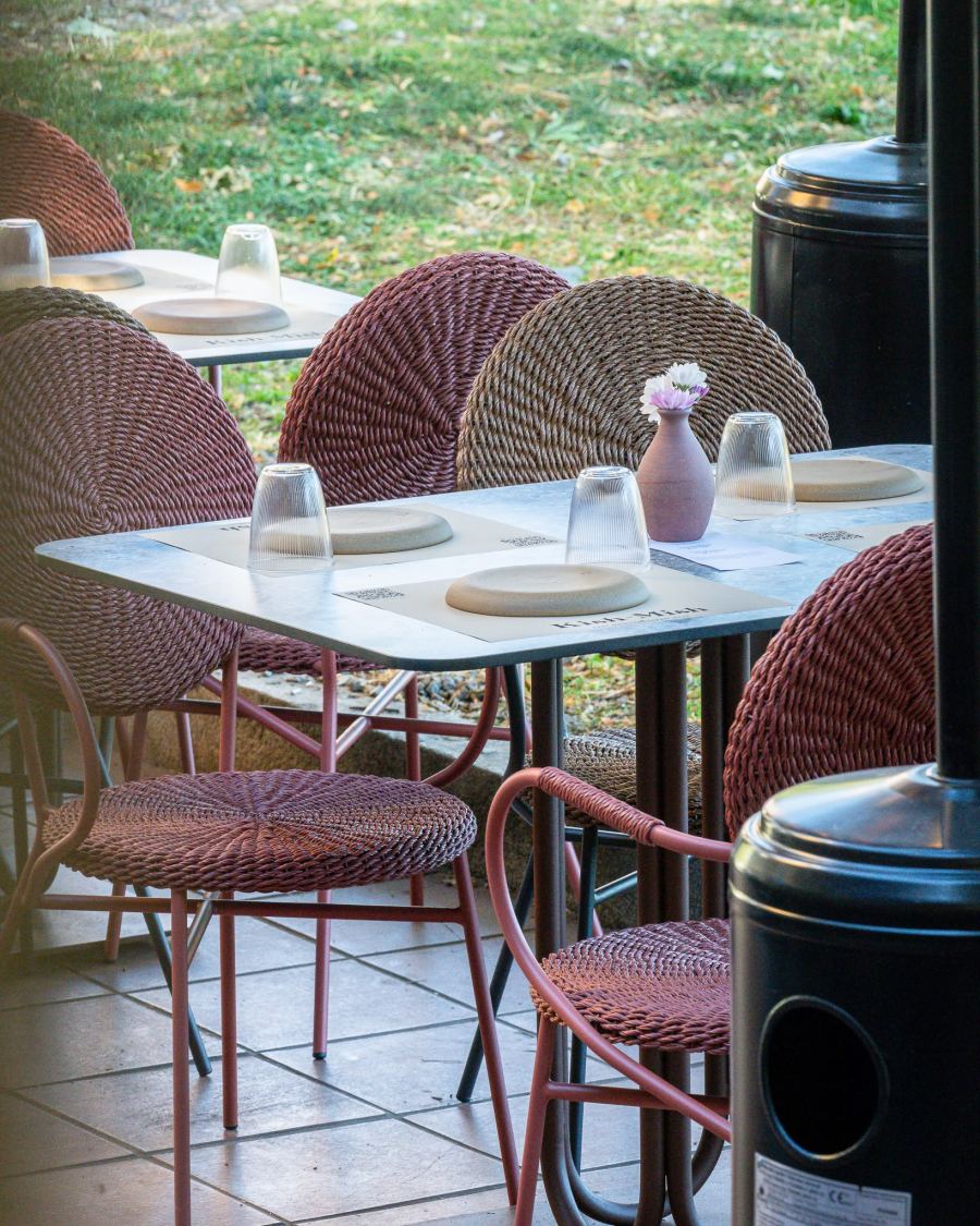 A terrace table set for two among wicker chairs