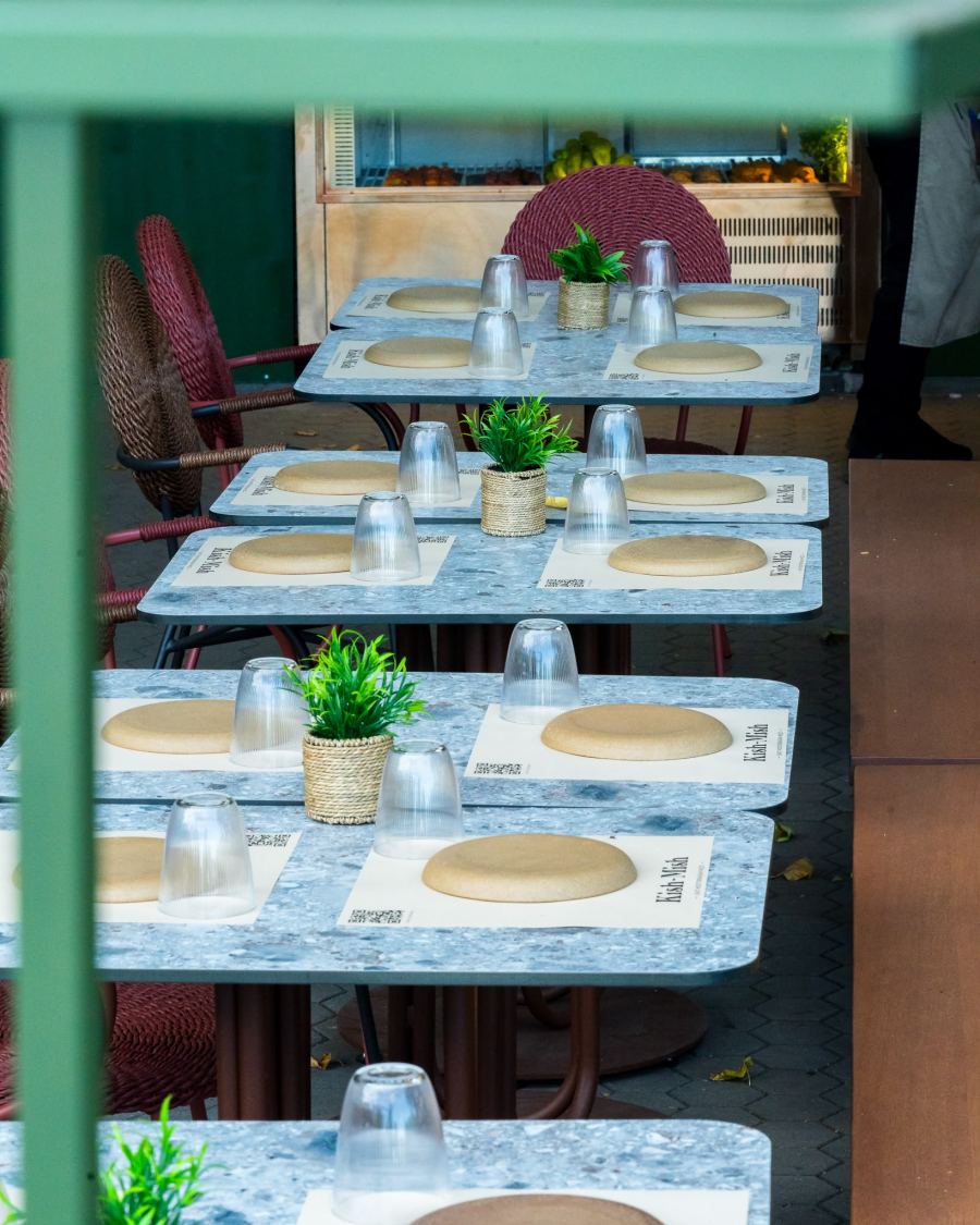 Terrace tables with little potted plants, ready for guests