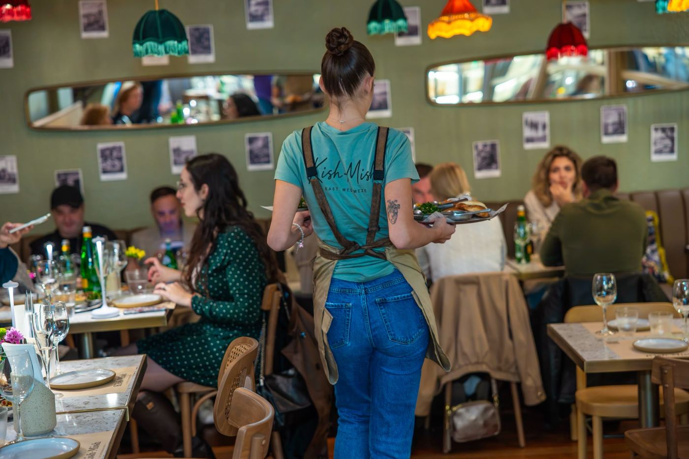 A server carrying plates through the lively dining room